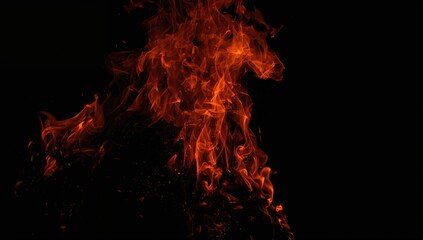 Obraz premium Fire flames on black backdrop, highlighting risk of uncontrolled burning