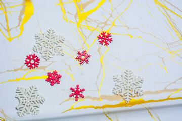 Top view of beautifully wrapped Christmas gifts with red and green ornaments, fir branches, and festive decorations on a light background