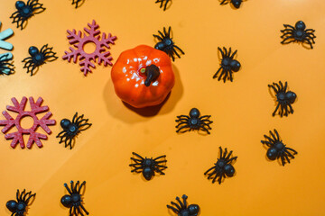 Halloween double border of scattered candy and decor. Flat lay over an orange background with copy space.