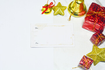 Top view of beautifully wrapped Christmas gifts with red and green ornaments, fir branches, and festive decorations on a light background