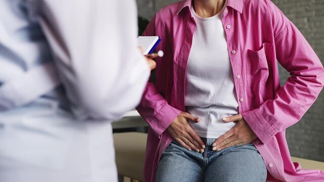 Woman complaining to urologist about pain in lower abdomen, medical check-up