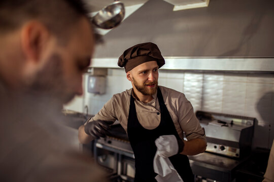 Young adult chef working in restaurant kitchen