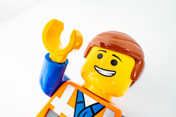 Fototapeta premium Bradford, UK Oct 30 2025 - Lego Emmet plastic toy shot close up on a white background. With one arm raised in greeting.