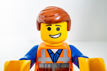 Obraz premium Bradford, UK Oct 30 2025 - Lego Emmet plastic toy shot close up on a white background. His arms raised forward embracing the camera.
