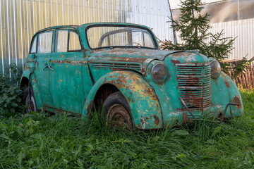 Vintage Rusty Car Abandoned in Overgrown Grass