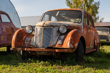 Vintage Rusty Car in Overgrown Grass Setting
