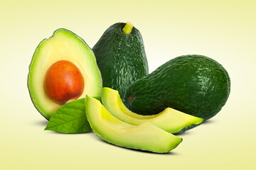 Fresh avocados and green leaves on beige background