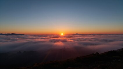Vibrant colors illuminate the foggy sea landscape at dawn, highlighting the beauty of nature's morning transition