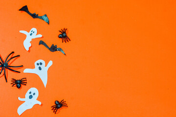 Halloween double border of scattered candy and decor. Flat lay over an orange background with copy space.