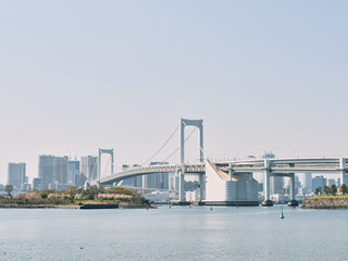 Rainbow Bridge Tokyo with city skyline and calm sea