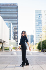 Young woman dancing urban area listening music