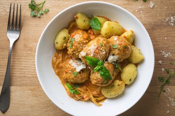 Fototapeta premium Creamy sauce gnocchi paired with chicken meatballs and fresh ingredients, overhead flat lay