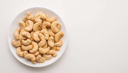 Raw natural cashew nuts served on a white dish with a bright backdrop, ample space for text. Rich in healthy fats, proteins, and oils. Ideal for ketogenic diet and nutritious snacking. Nut oil packed