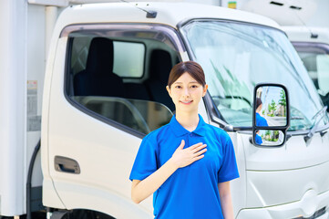 胸に手を当てる女性ドライバー 配送スタッフ