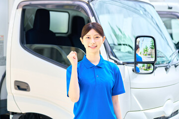 ガッツポーズする女性ドライバー　配送　物流　引っ越しセンター