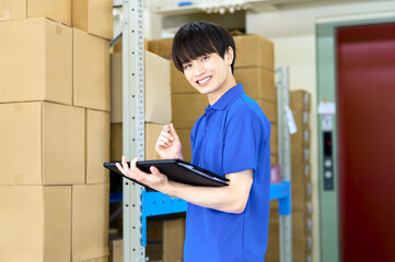 在庫確認する男性作業員　倉庫　配送センター