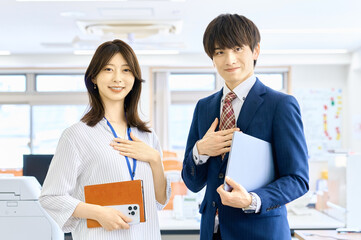 胸に手を当てる会社員の男女　ビジネスシーン　チーム