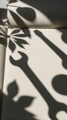 A play of shadows highlights a blend of tools and leaf patterns on a light surface. The sunlight softly filters through, creating a tranquil atmosphere filled with nature's touch