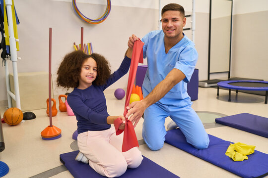 Pediatric physiotherapist working with child, rehabilitation exercises, balance training, motor skills development, physical therapy session in pediatric rehab center