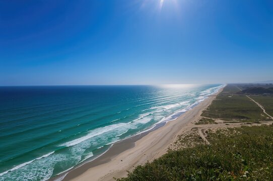 Amazing coastal scenery featuring ocean backdrop, water, sandy shore, summer vibes, vacation, natural beauty, terrain, open area, sunlight, attractiveness