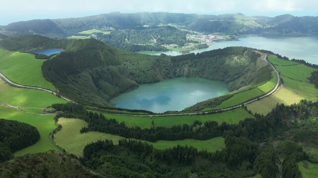 Drone 4K capture of volcanic caldera landscape with lush vegetation and dramatic ridges under bright daylight &mdash; great for geographical or nature footage