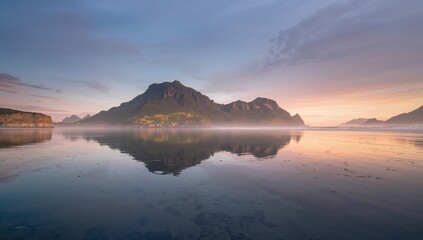 Fototapeta premium Scenic mountain reflection on water beneath a misty sky, erosion risk