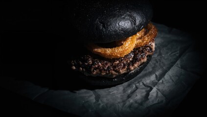 Black burger featuring meat and onion rings, processed meat risk