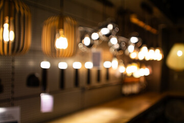 Abstract, blurred view pendant lamps on display in a lighting showroom.  Wide angle view, bokeh background, no people