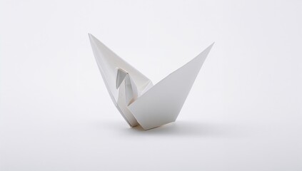 Paper origami bird on a plain white backdrop