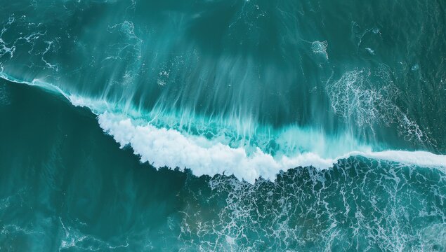 An impressive aerial shot showcases a powerful ocean wave crashing and creating a white mist over the dark sea, inspiring a sense of wonder