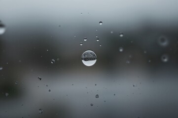 Water Droplet Clinging to Glass Pane