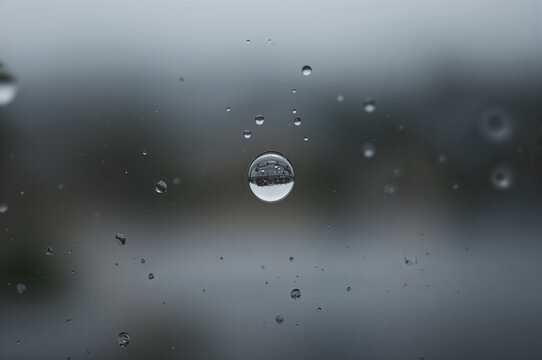 Water Droplet Clinging to Glass Pane