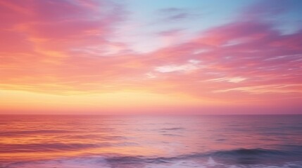 Obraz premium Tranquil seascape at sunset, featuring vibrant pink and blue clouds reflecting on calm ocean waves.