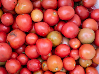 Top view A pile of ripe red tomatoes captured in natural light, showing freshness and organic produce from highland farms.