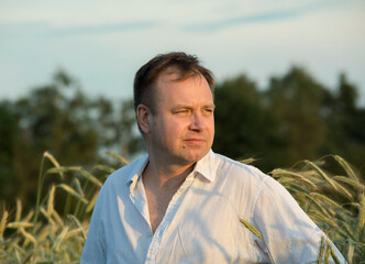 Man in white shirt standing in rye field