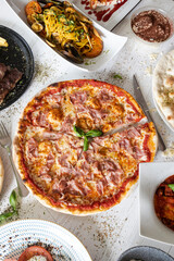 Italian food feast with prosciutto pizza and seafood pasta