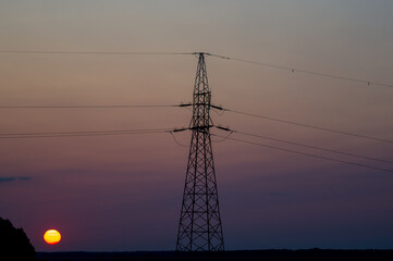 Słup elektryczny na tle wschodzącego słońca .
