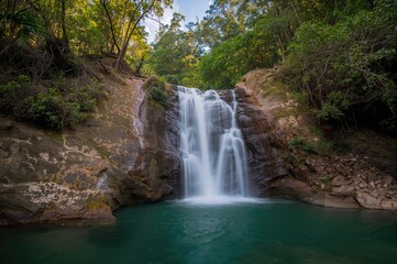 Obraz premium Tropical Jungle Waterfalls with Lush Greenery and Flowing Water in Summer