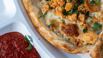 Chicken cheese pizza with tomato sauce served on white tray, close-up