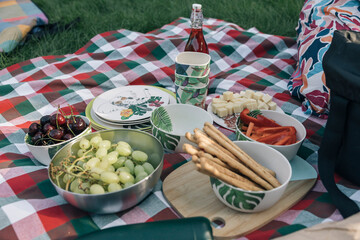 Picnic blanket with fresh fruit, vegetables and snacks