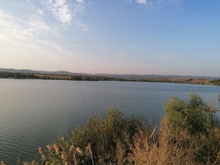 Serene Lake and Rolling Hills Landscape at Golden Hour Sunset
