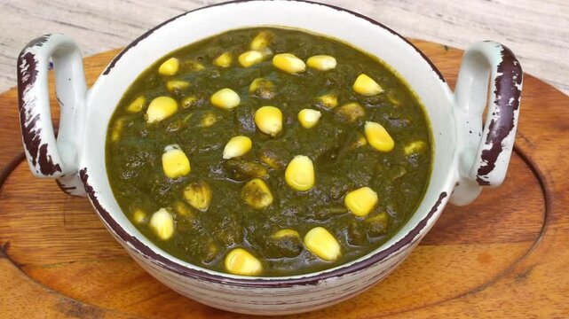 Healthy palak corn in a kadhai bowl with wooden background.
