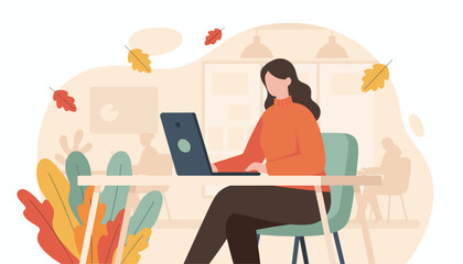 Professional woman working on laptop in a cozy autumn office environment