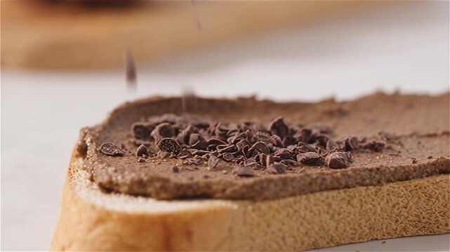 Macro shot of cacao nibs being sprinkled over creamy sacha inchi butter toast, capturing the crunchy texture, nutty aroma, and rich chocolate contrast, protein breakfast and superfood indulgence.