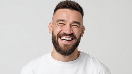 Obraz premium Cheerful Man Smiling Broadly as He Showcases His Clean White Teeth Against a Simple Light Background