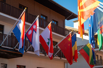 Colorful flags of different nations decorate a building during a sunny day in a vibrant locale