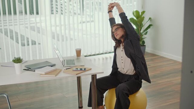 Sustainable Office and Employee Wellness. Businesswoman Stretches on Fitness Ball at Desk, Promoting Green Workplace, Eco Lifestyle, Active Posture, Work Life Balance and Healthy Corporate Culture