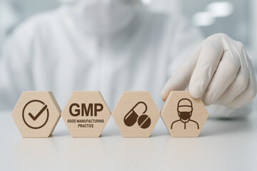 Focused scientist arranging wooden hexagons for GMP quality control. Pharmaceutical production standard concept with icons in sterile laboratory background showing focused compliance