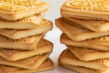Shortbread cookies with patterns stacked like two towers, macro shot, selective focus. Cookie texture, fresh baked goods, background for culinary recipe