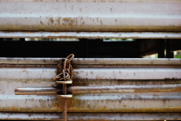 Livestock trailer latch and closure system for lock closeup on rusty old surface.